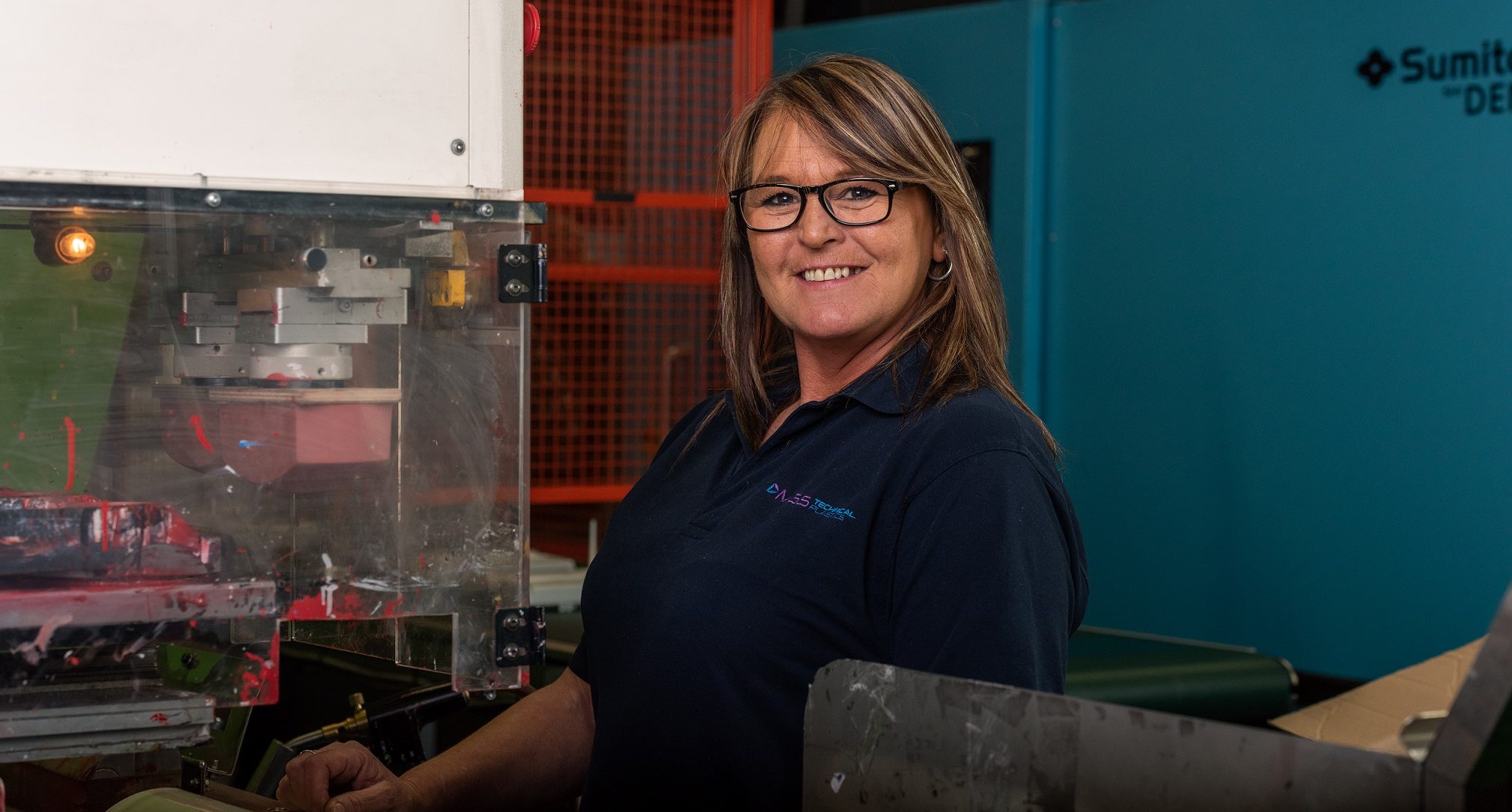 Employee working next to injection moulding machine