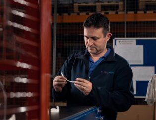 Employee inspecting plastic part